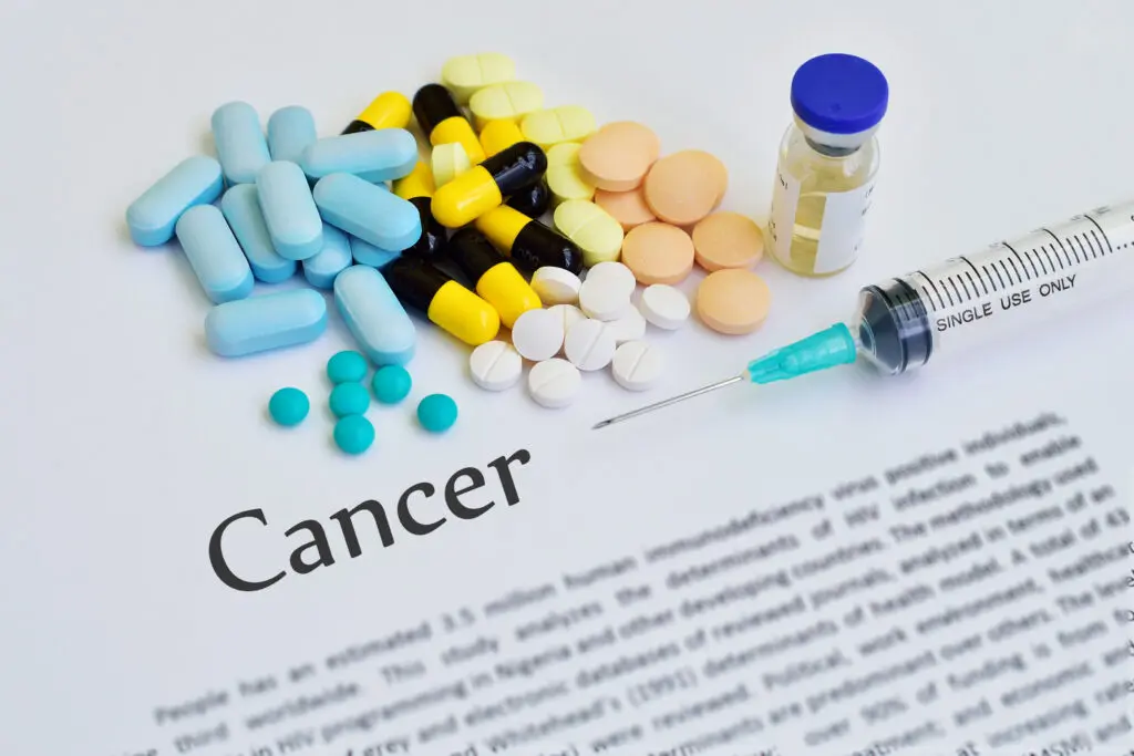 Various medications are arranged around the word "Cancer".