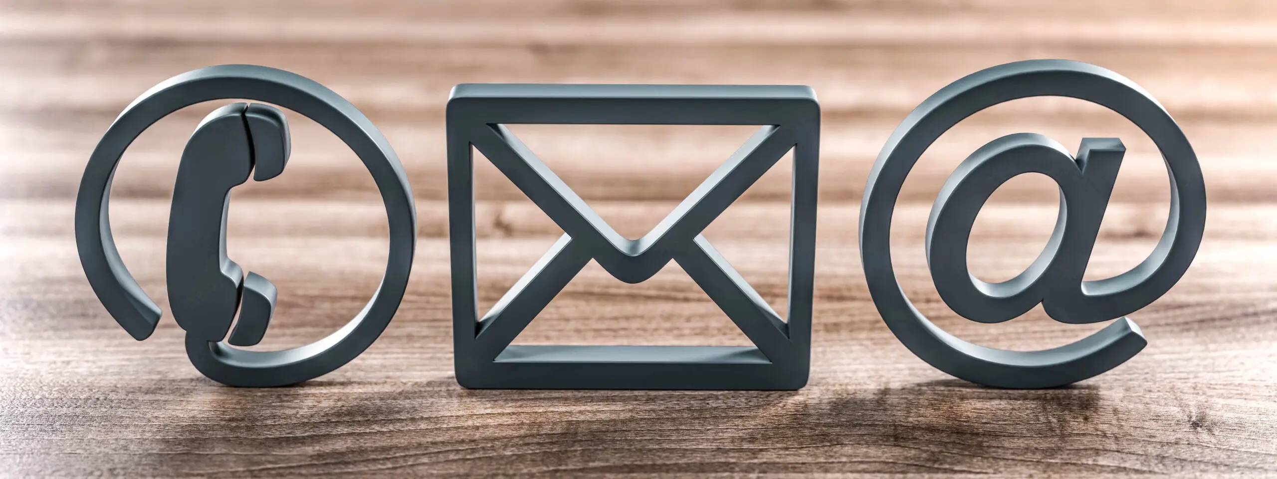 Contact symbols for telephone, letter and email on a table