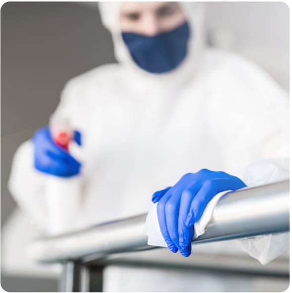 a cleaner disinfecting the hand rail