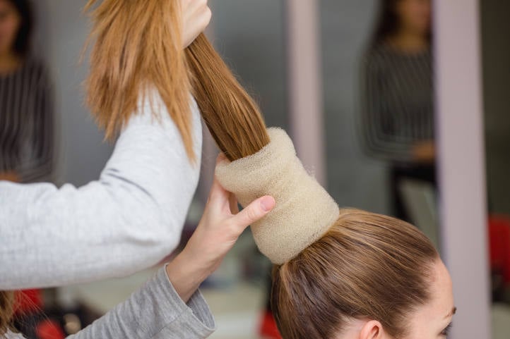 a ballerina having her hair styled into a bun