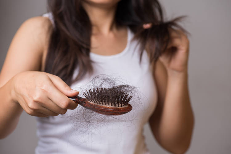 Woman checks hair brush and sees hair loss