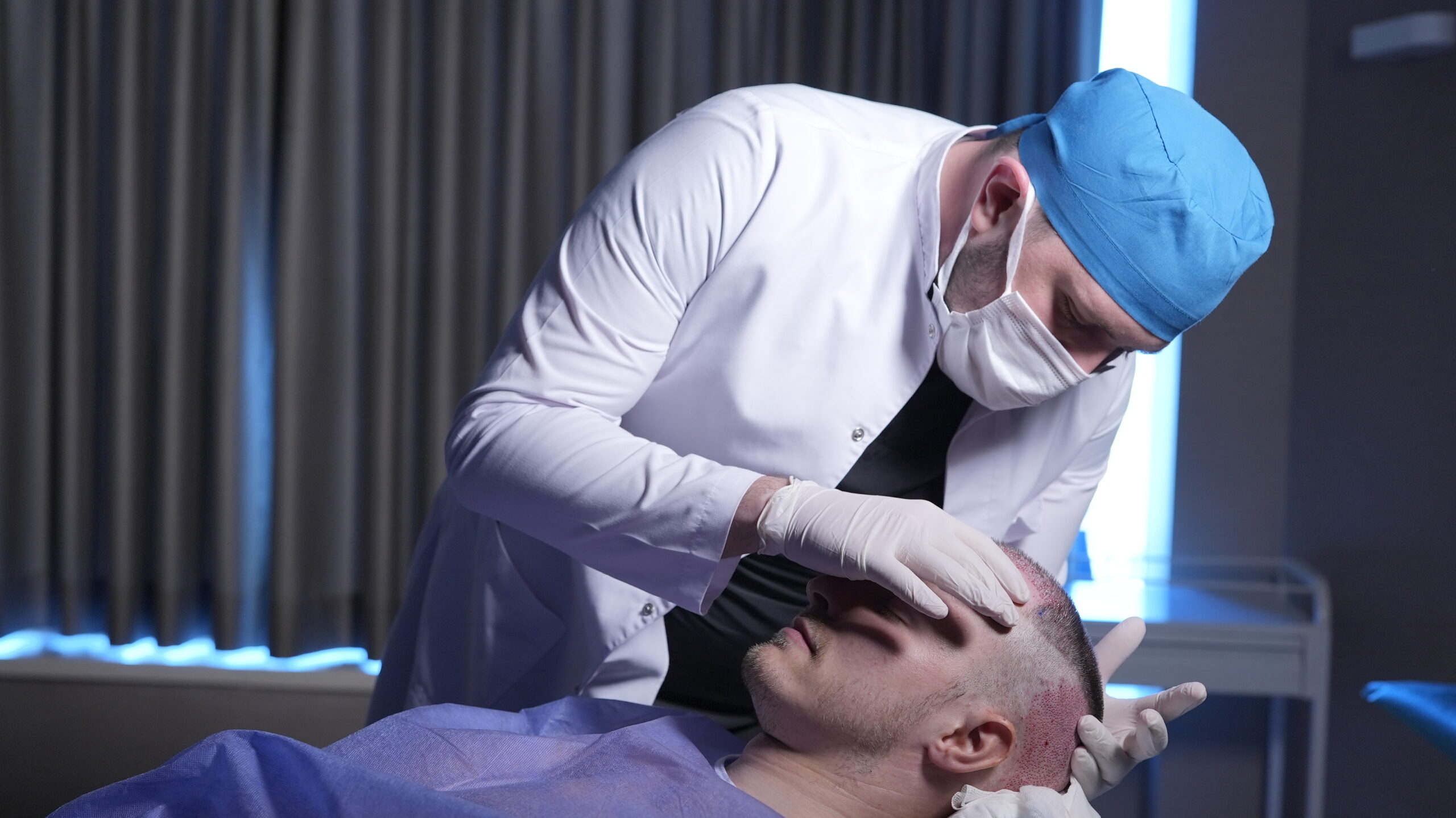 Hair transplant surgeon with patient during operation