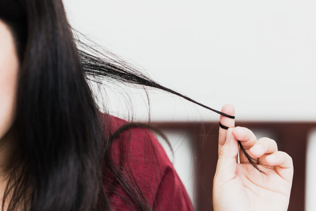 Woman pulling hair from trichotillomania