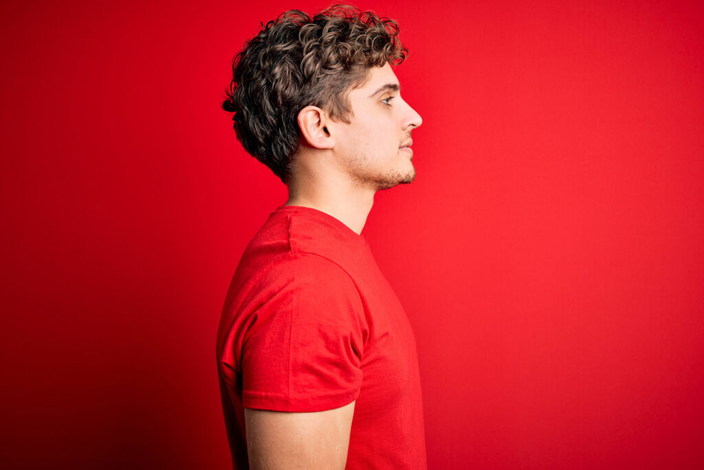 Side profile of man on red background