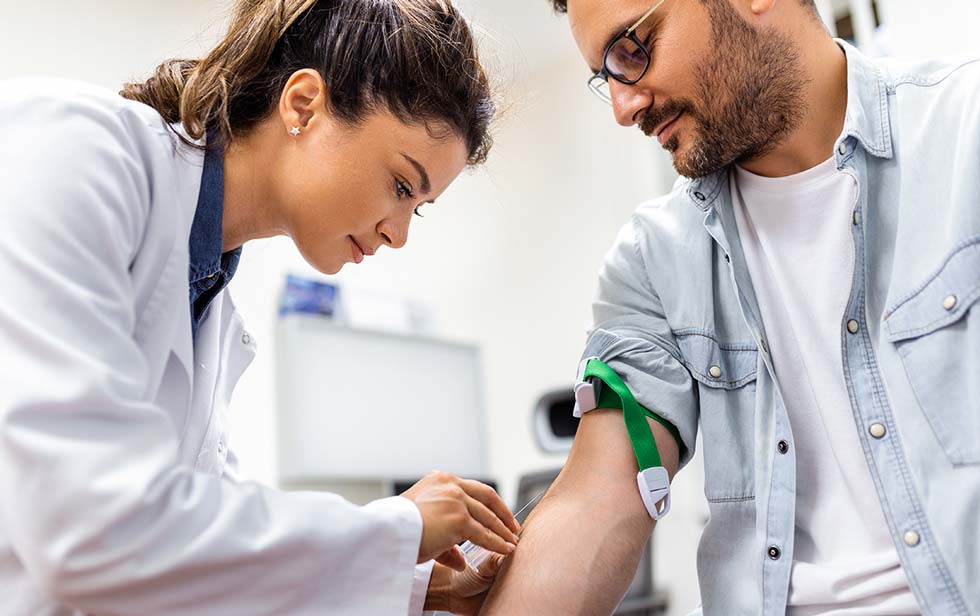 a doctor is taking a blood sample from a patient
