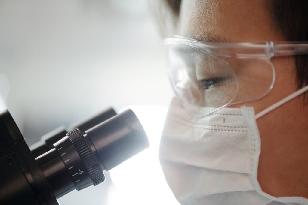 Doctor using a microscope to analyse micrografting mixture