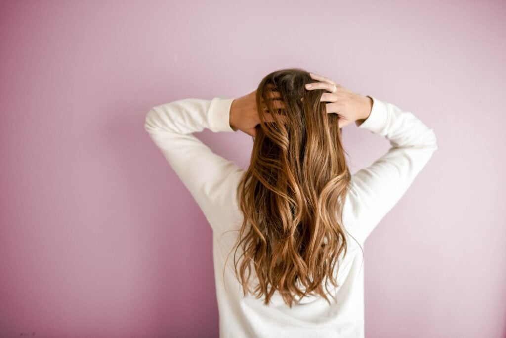 Back of woman running hands through her hair