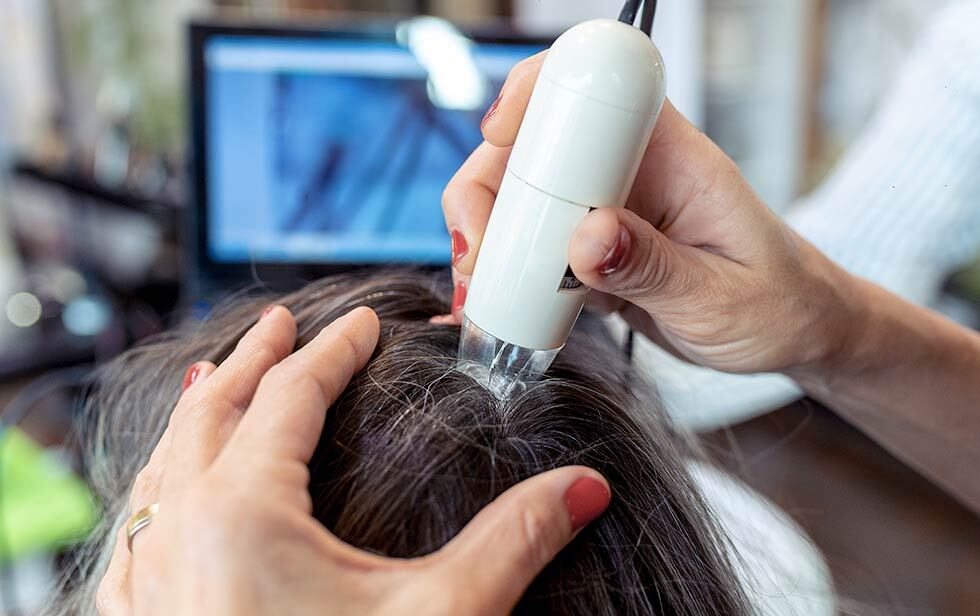 medical staff scanning a patient's scalp with ultrasound