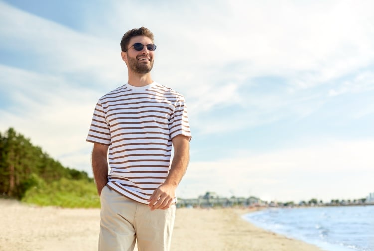 picture of a man walking on a beach during the summer