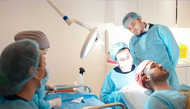 Dr. Balwi observes his specialist-team while they perform a hair transplant in Turkey