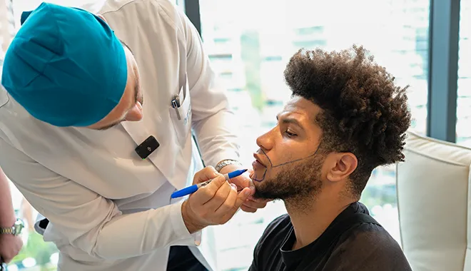 Dr Balwi drawing the beard line on a hair transplant patient at Elithair clinic.