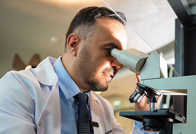 Dr Mustafa with Microscope in Clinical Research – Elithair