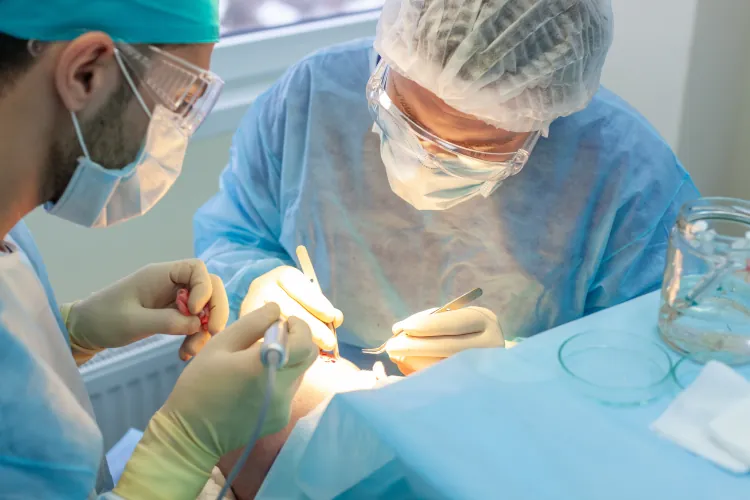 Medical team in surgical gowns and masks performing a hair transplant procedure