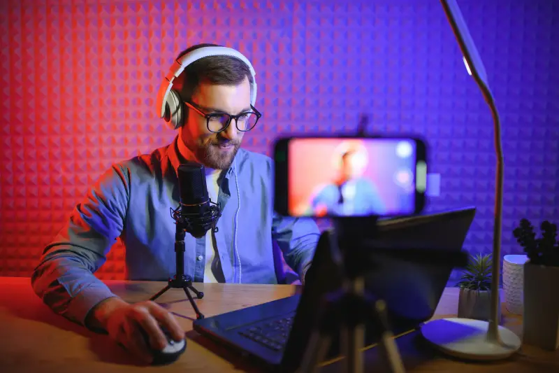 A young man with headphones and a microphone in a studio