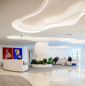 Elithair hair loss clinic's lobby area with stylish lighting, white sofas, indoor plants, and colourful portrait paintings on the wall.