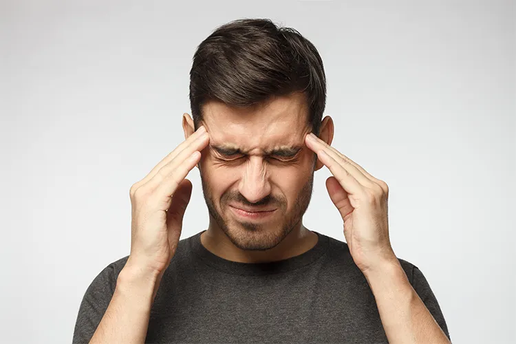 A man rubs his temples.