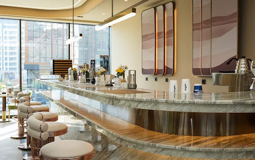 The modern cafe and bar area in the Elitoria Hotel, featuring marble counters and a bright atmosphere.