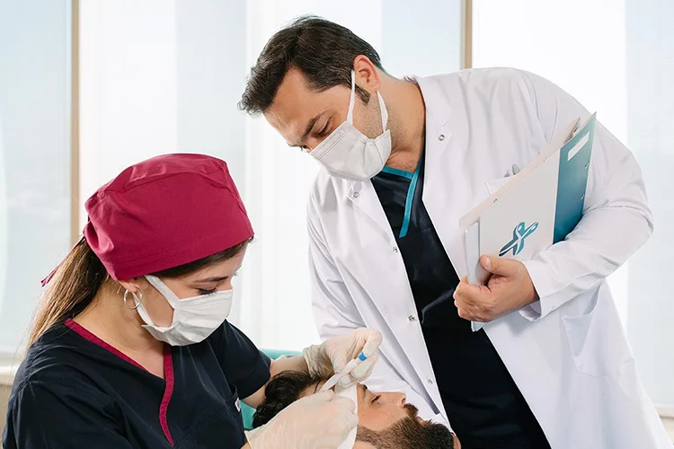 Elithair medical director, Dr. Balwi, assists during a hair transplant.